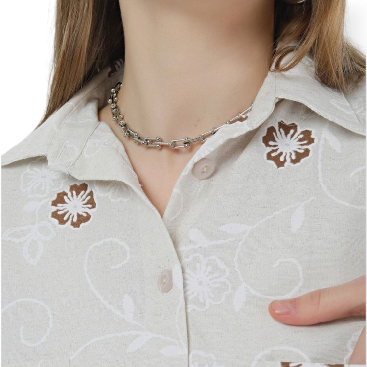 نمای نزدیک بافت پارچه لینن شومیز زنانه ترک – گل قهوهای روی زمینه کرم