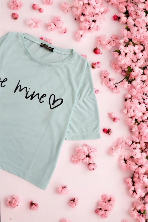 نمای نزدیک از بافت پارچه سبز دریایی تیشرت زنانه ترک